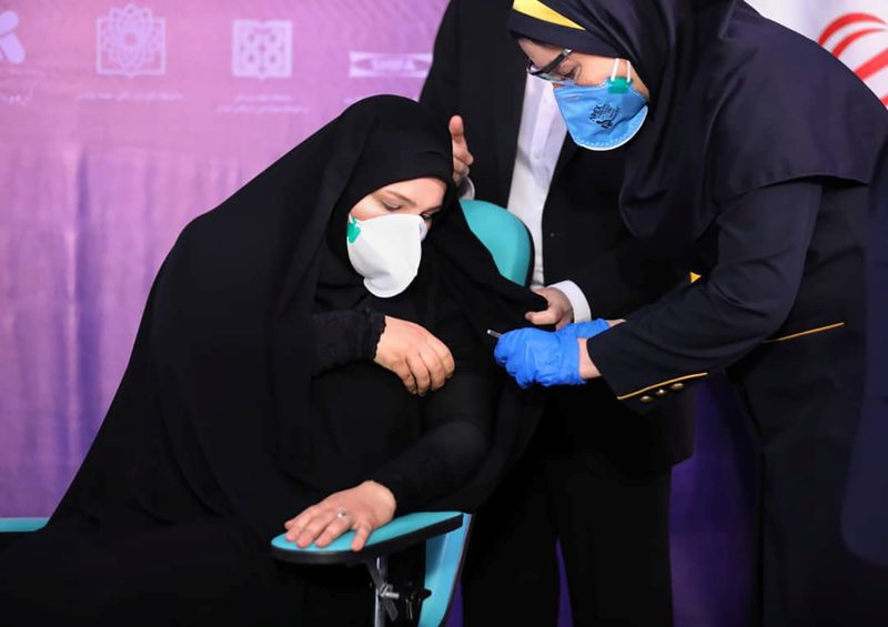 A nurse prepares to inject a volunteer taking part in
