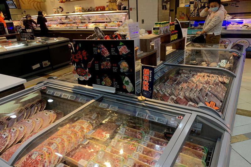 FILE PHOTO: Woman checks imported frozen meat at a supermarket
