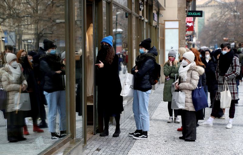 FILE PHOTO: Customers queue in front of a reopened shop