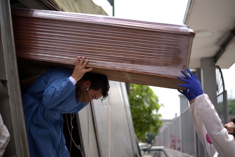 Workers unload empty coffins sent from Quito to Ecuador’s social