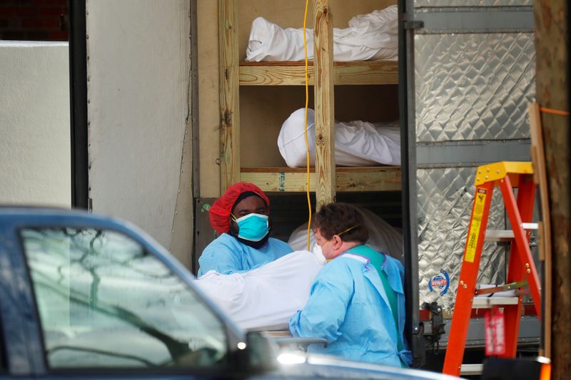 Healthcare workers transfer a body at Kingsbrook Jewish Medical Center