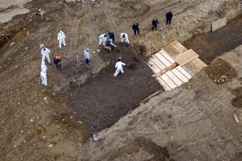 FILE PHOTO: Drone pictures show bodies being buried on New