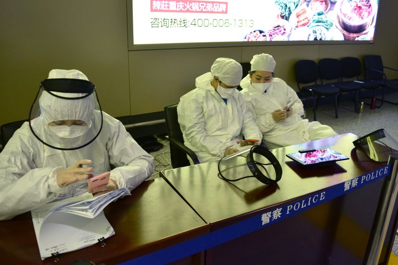 Workers in protective suits are seen at a registration point