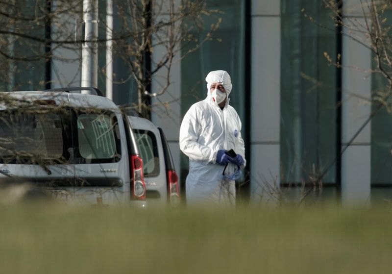 A medical specialist stands outside a hospital for patients infected