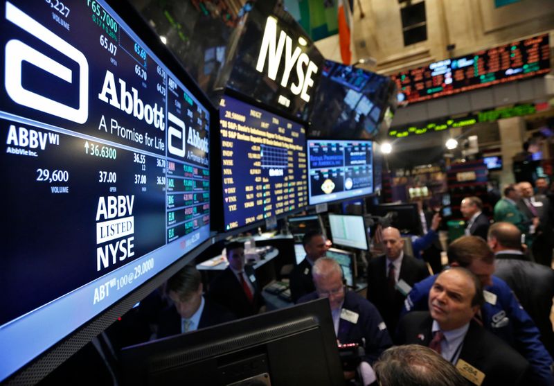 Traders gather at the booth that trades Abbott Laboratories on