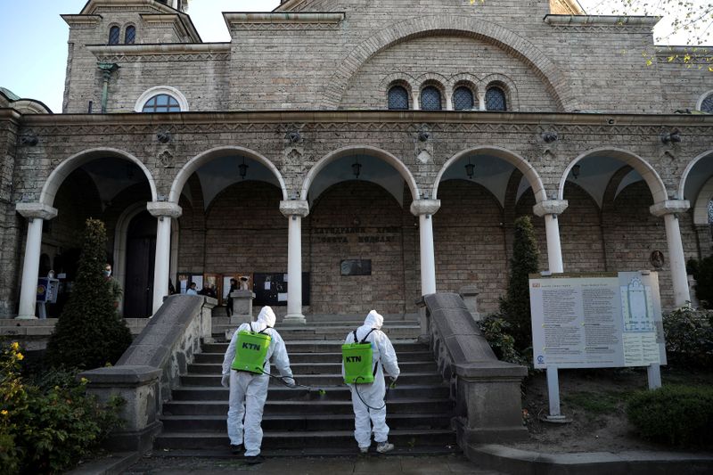 FILE PHOTO: Workers spray disinfectant outside St Nedelya church