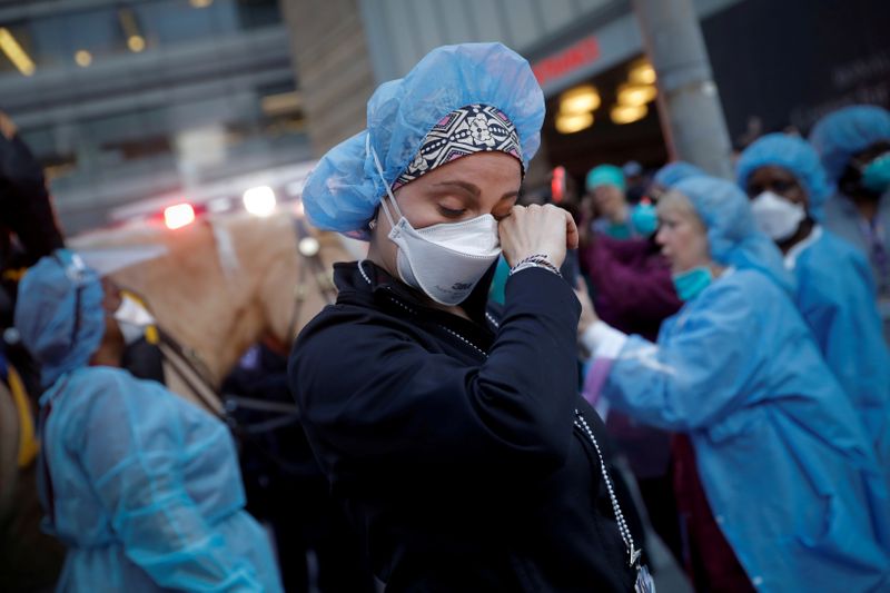 FILE PHOTO: Nurse wipes away tears as NYPD polioce thank