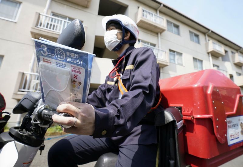 A mail carrier delivers cloth masks under a government program