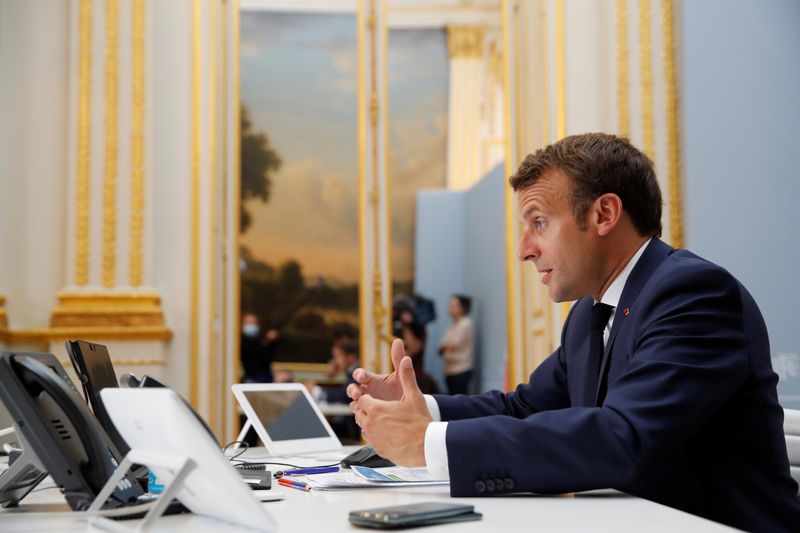 French President Emmanuel Macron speaks with Tedros Adhanom Ghebreyesus, Director
