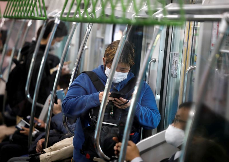 FILE PHOTO:  Passengers wearing protective face masks, following an