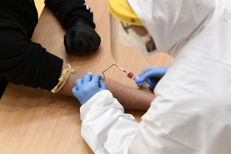 FILE PHOTO: Medical workers take blood samples for the coronavirus