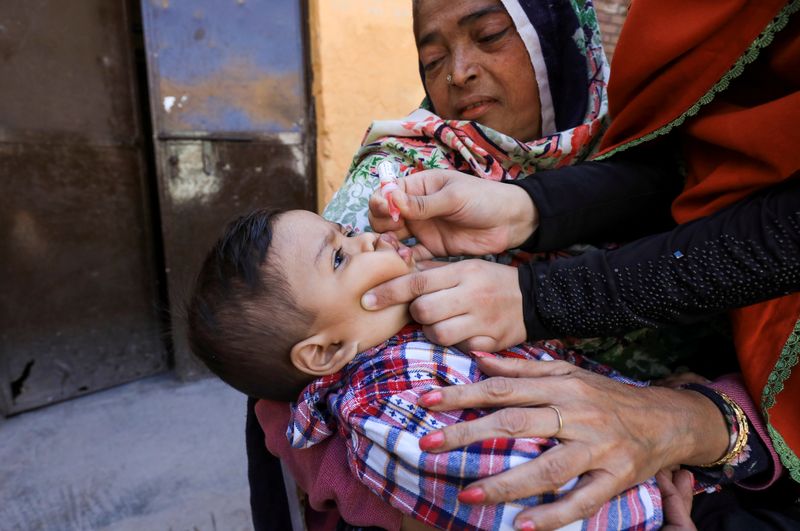 FILE PHOTO: A boy receives polio vaccine drops during an