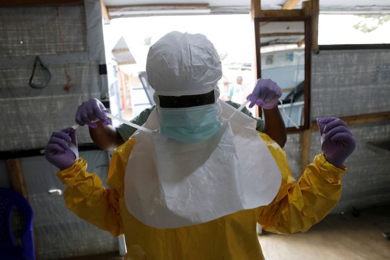 FILE PHOTO: A health worker puts on Ebola protection gear