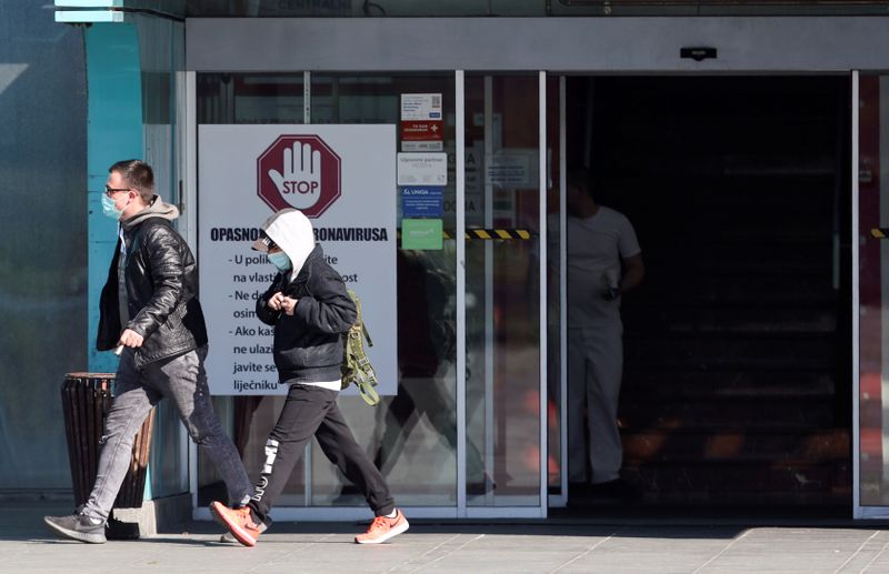 People wearing face masks are seen exiting the Dubrava hospital