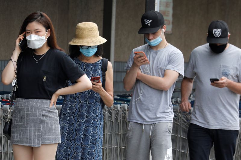 People wear protective face masks outside at a shopping plaza