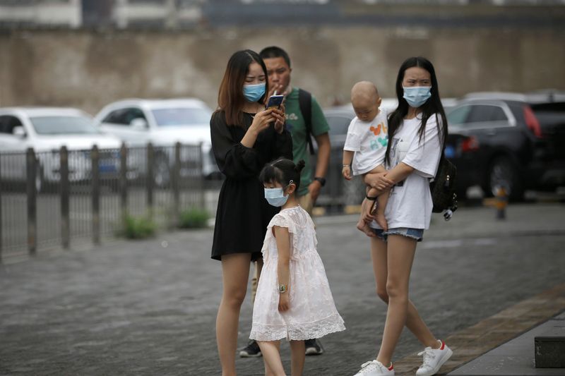 Women and a kid wearing face masks are seen on