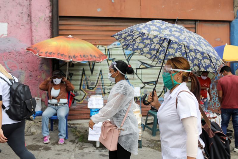 Doctors walk in front of street vendors during a walking