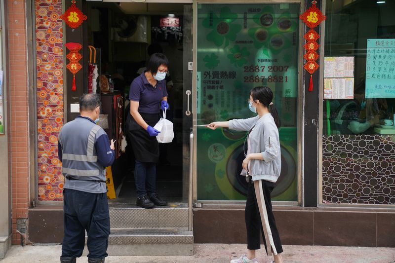 FILE PHOTO: Staff member hands takeaway food to a customer