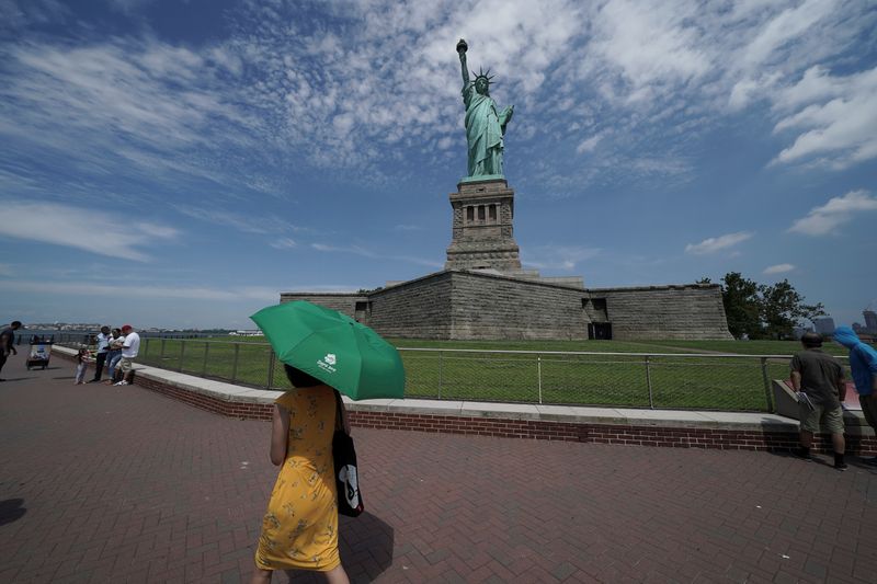 People are seen at the Statue of Liberty as New
