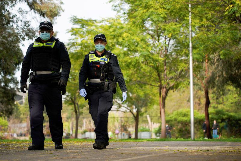 Police officers patrol the grounds outside a public housing tower,