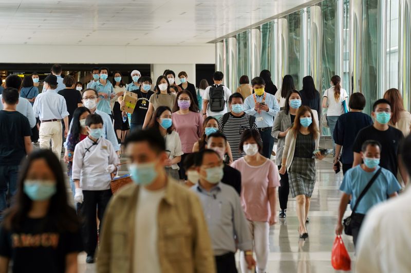 People wearing face masks walk at a shopping mall in