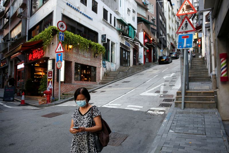 A woman wears a surgical mask while walking at Central