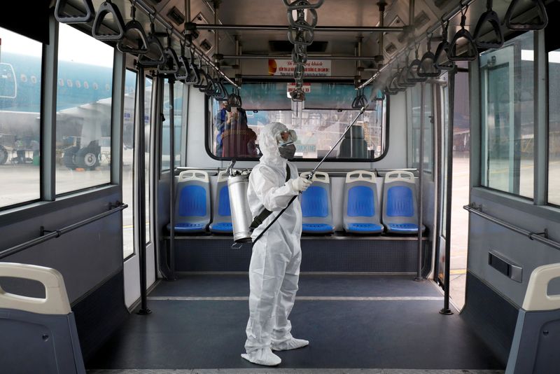 FILE PHOTO: A health worker sprays disinfectant inside a bus