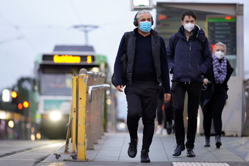 People wear face masks in Melbourne, the first city in