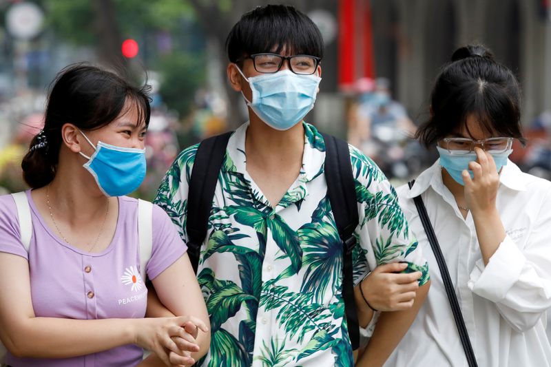 People wear protective masks as they walk down a street