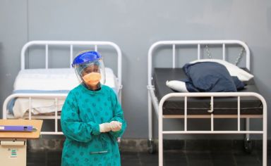 FILE PHOTO: A health worker walks between beds at a