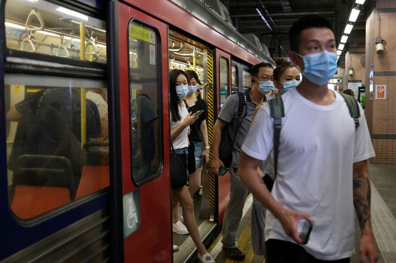 FILE PHOTO: People wear protective face masks at a Light