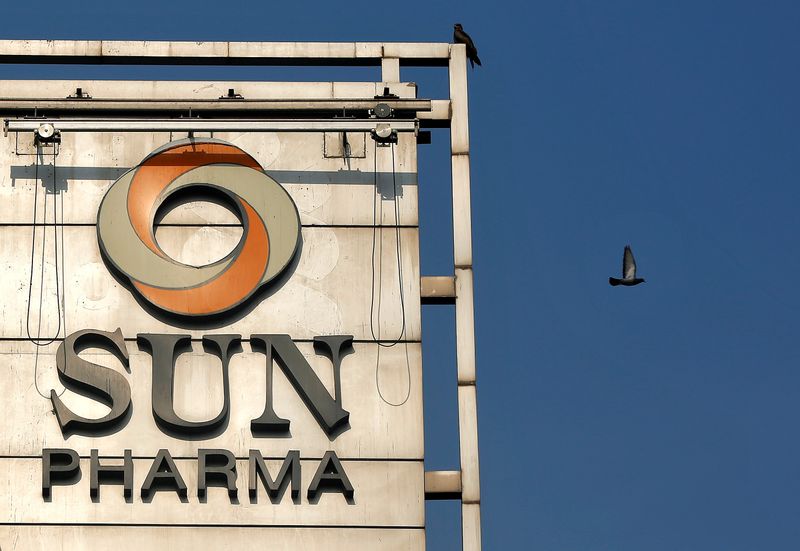 A bird flies past the logo of Sun Pharma installed