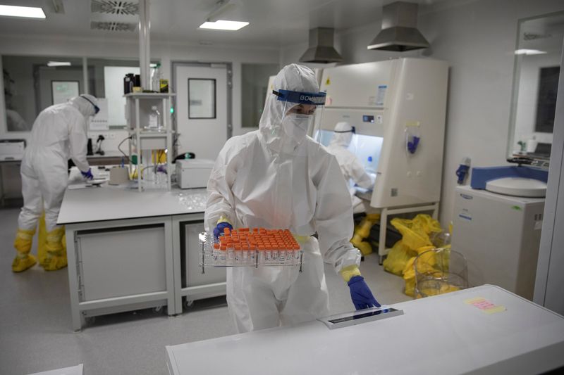 FILE PHOTO: Scientists work with samples taken for testing for