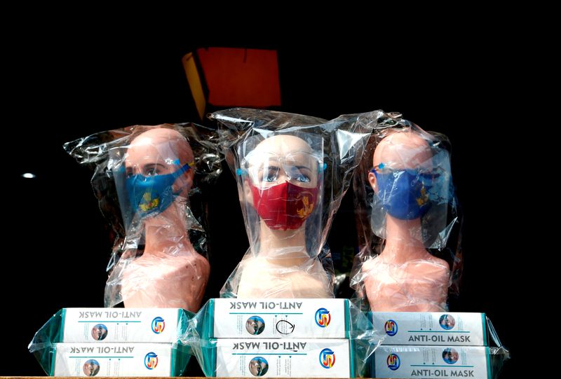 Mannequins wearing protective face masks and face shields are displayed