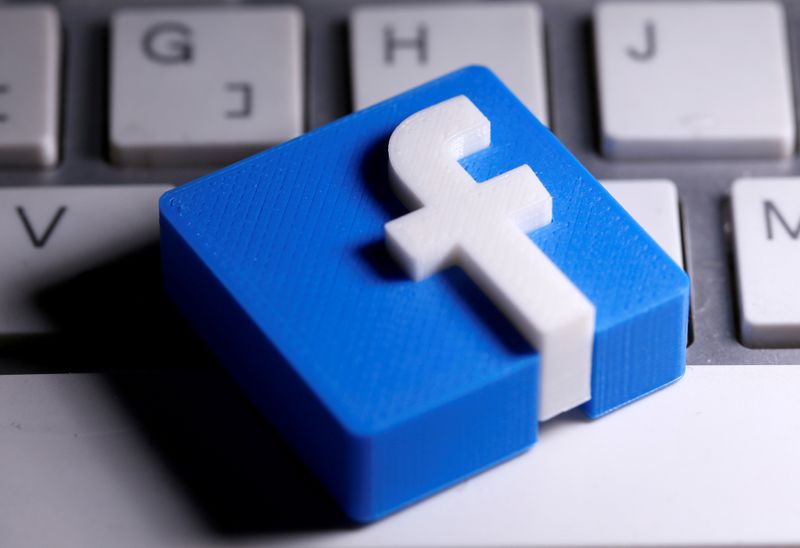 A 3D-printed Facebook logo is seen placed on a keyboard