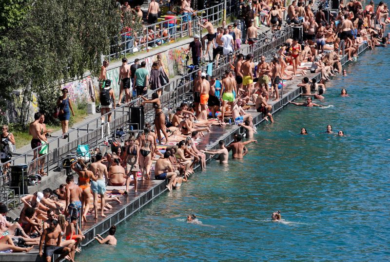People enjoy hot summer weather on the banks of the