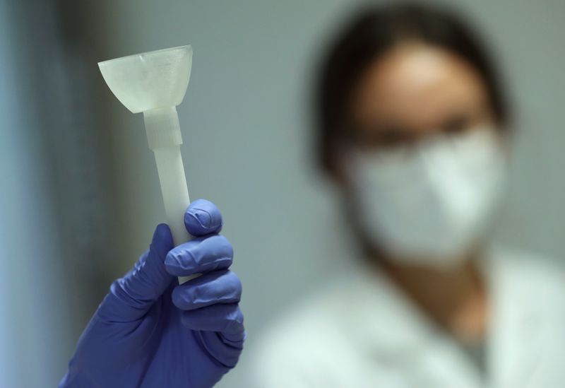 A laboratory worker shows a prototype of a self-test that
