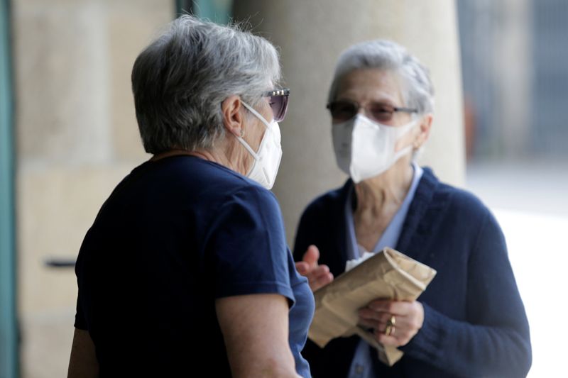 Women in protective masks talk during COVID-19 pandemic in Pontevedra