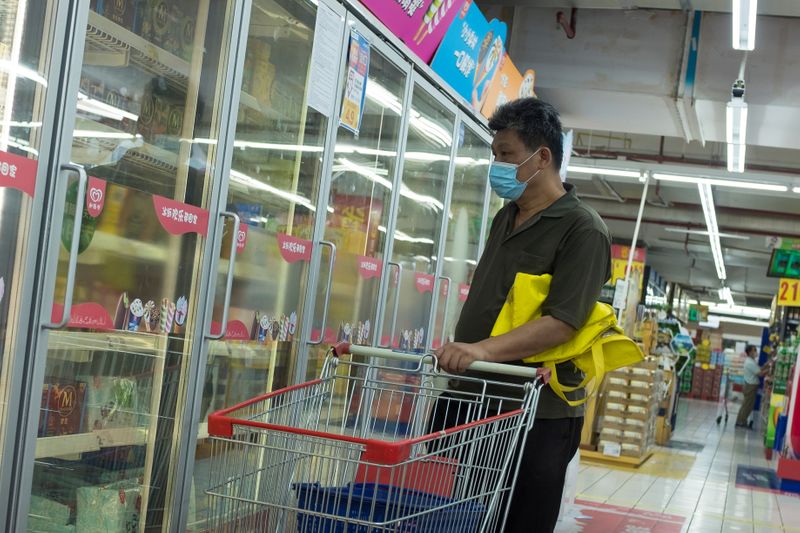A man looks at frozen food products in a supermarket