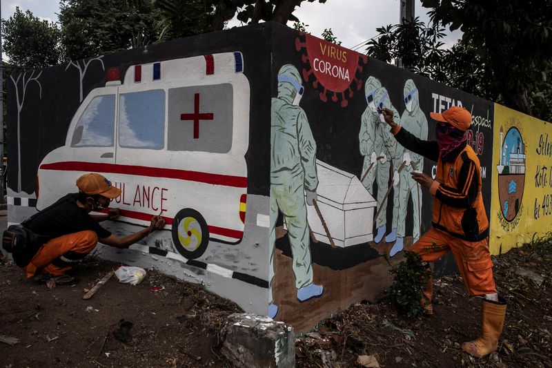 Workers paint a mural promoting coronavirus disease (COVID-19) awareness in