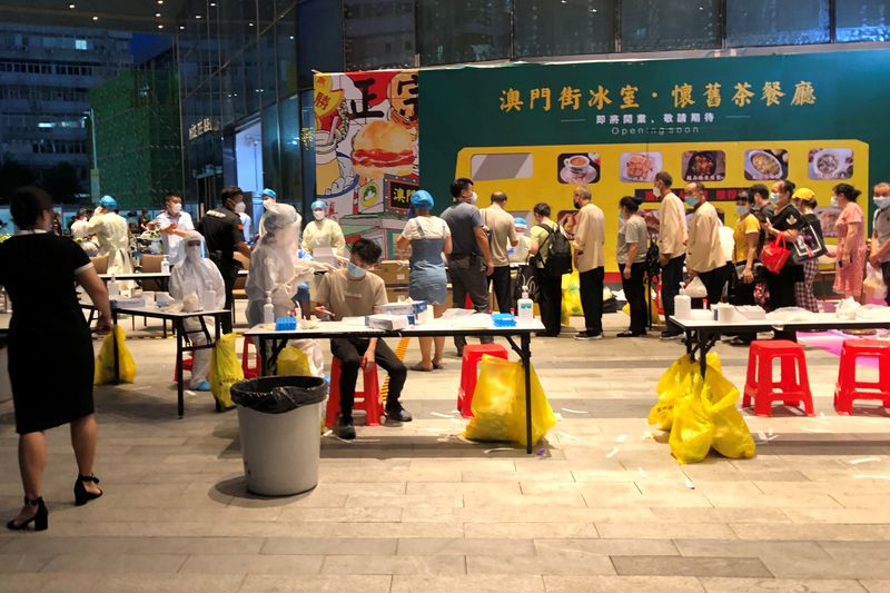 Medical workers wearing protective suits are seen at a nucleic