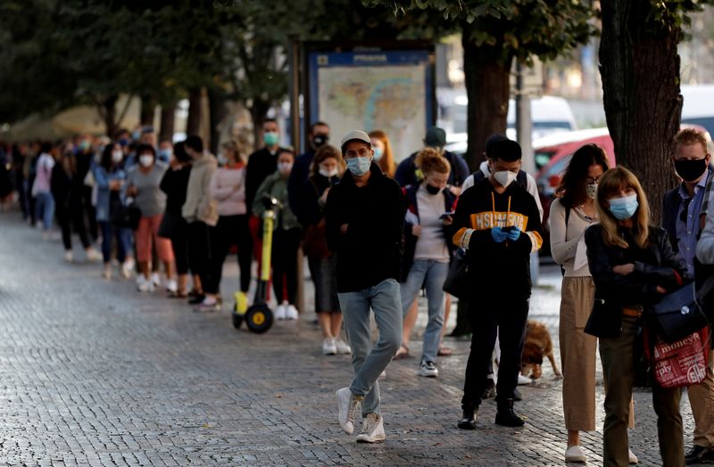 FILE PHOTO: People wait in line in Prague to be