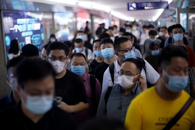 People wearing face masks arrive at Yiwu Railway Station