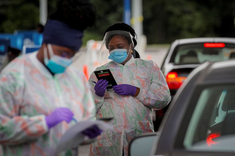 FILE PHOTO: Medical technicians work at a drive-through coronavirus disease