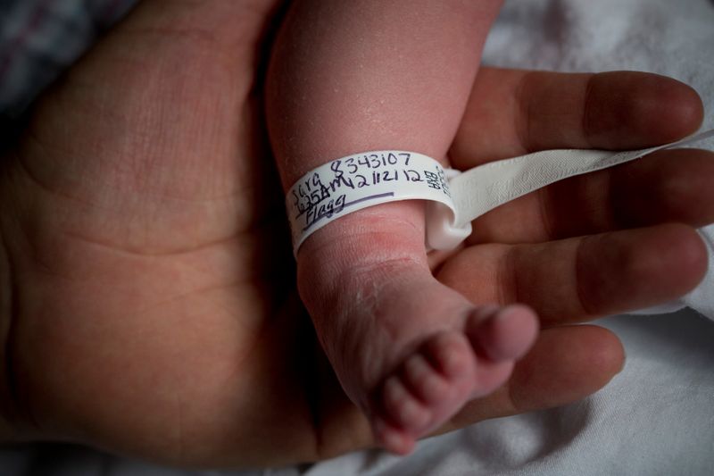 FILE PHOTO: Dale Smith holds the foot of his newborn