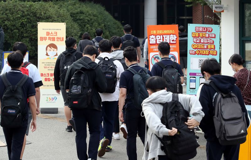 FILE PHOTO: High school students arrive at a high school,