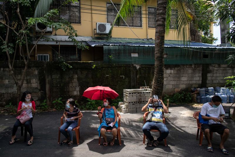 FILE PHOTO: Filipinos queue for government aid amid the coronavirus