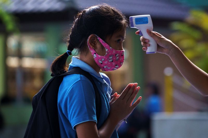 A student wearing a face mask has her body temperature