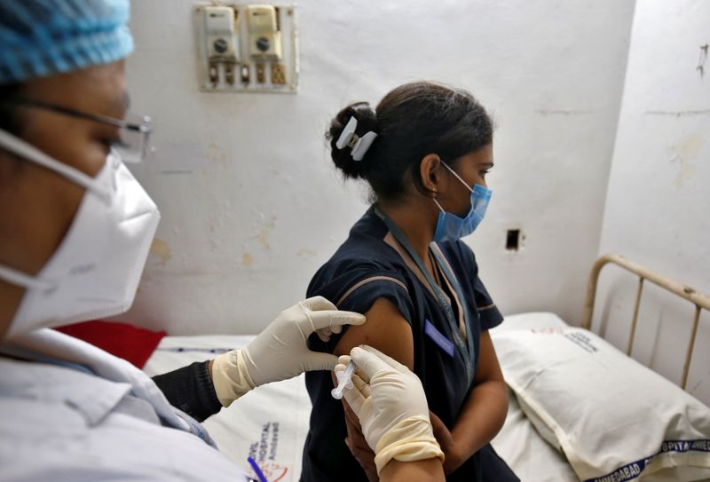 A paramedic administers a vaccine against the coronavirus disease (COVID-19)