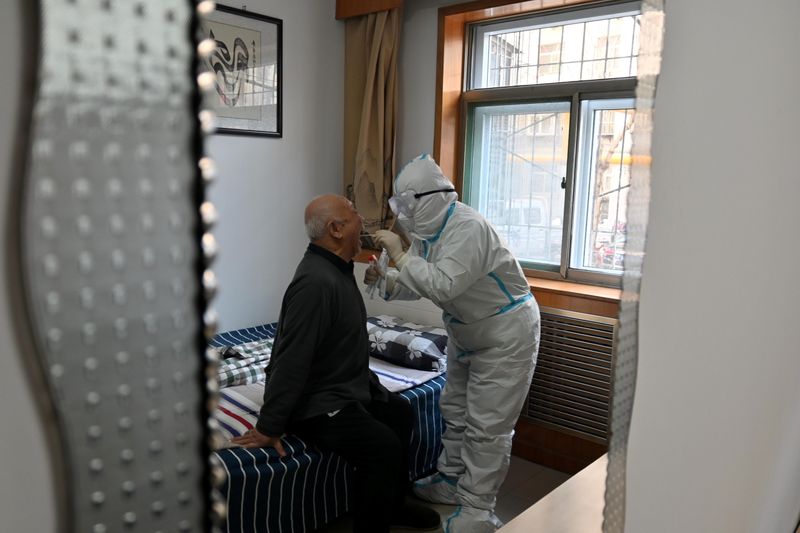 Medical worker in protective suit collects a swab from an
